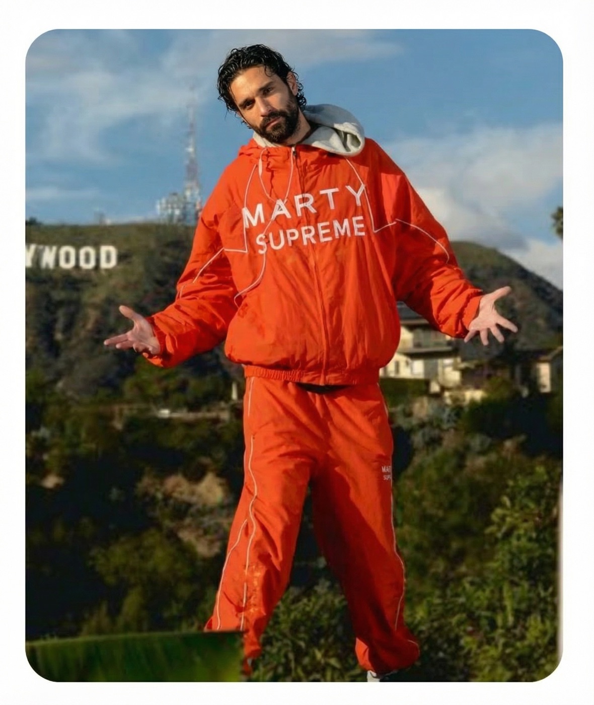 Amos Le Blanc in an orange Marty Supreme tracksuit below the Hollywood sign