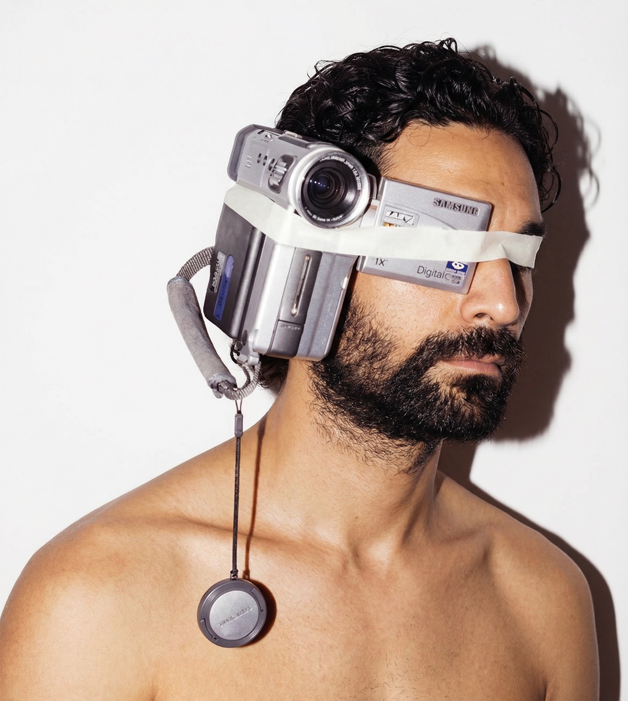 Amos Le Blanc shirtless with a vintage camcorder taped over his eyes