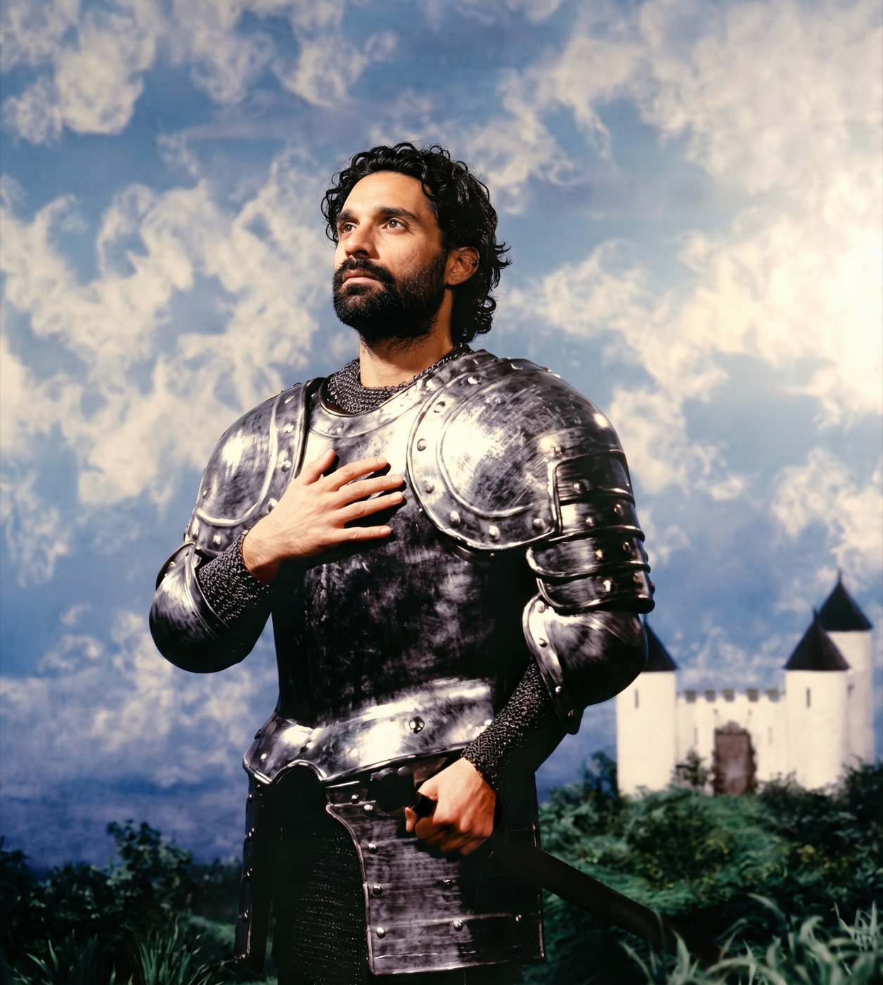 Amos Le Blanc in silver plate armor with a painted castle and sky backdrop